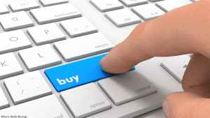 Person pressing buy button on keyboard, illustrating media buying concept.